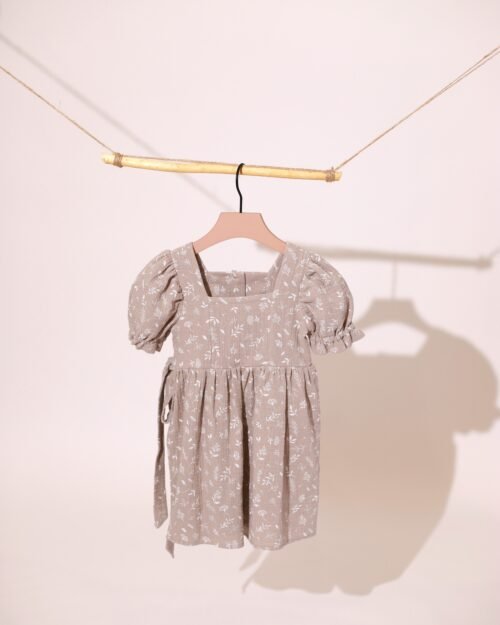 ruda muslino suknele su dirzeliu mergaitei